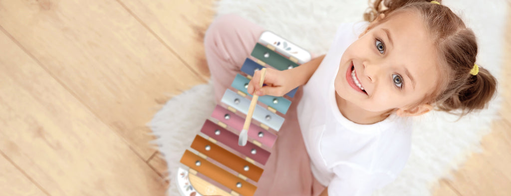 little girl playing with a metalic xylophone